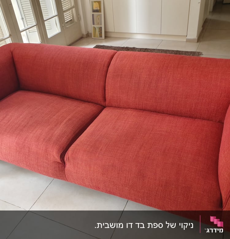 ספה אדומה על רצפת אריחים בהירה